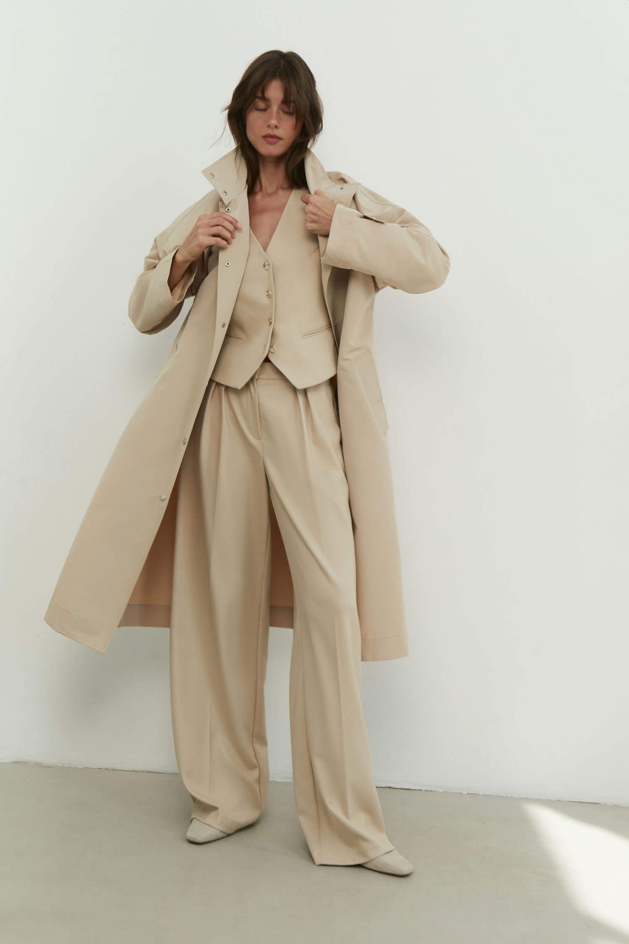 Trenchcoat with a free cut in cream/black