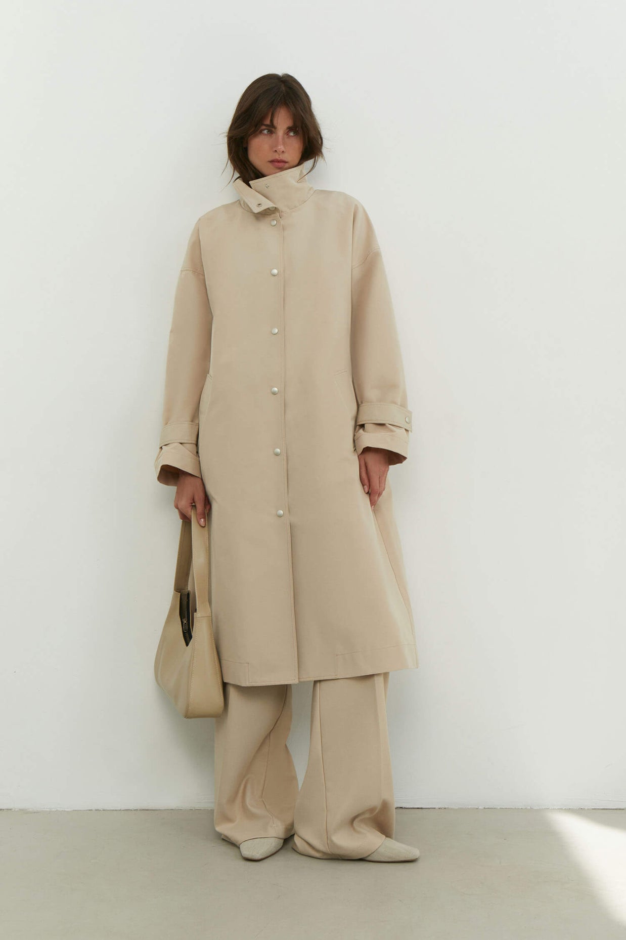 Trenchcoat with a free cut in cream/black