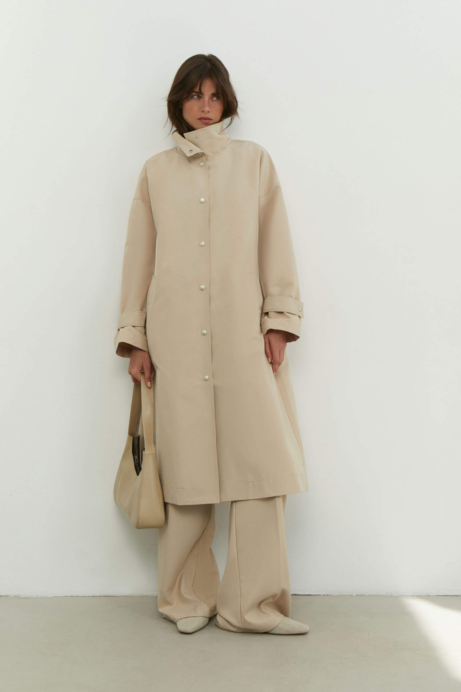 Trenchcoat with a free cut in cream/black