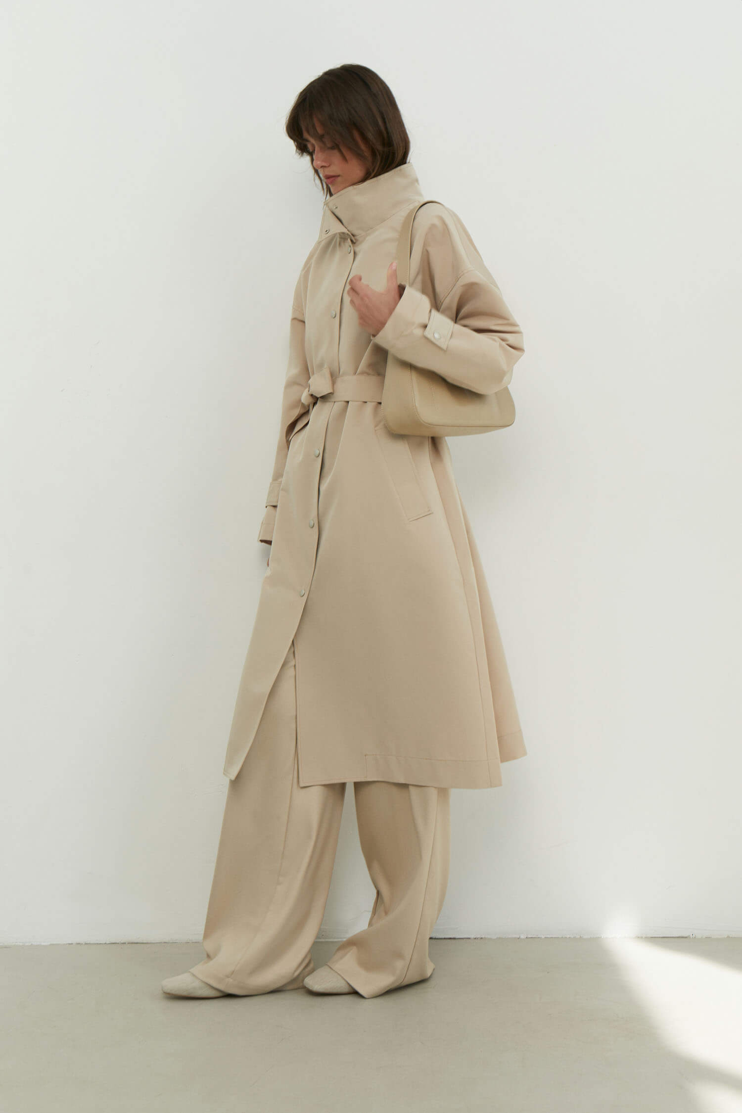 Trenchcoat with a free cut in cream/black