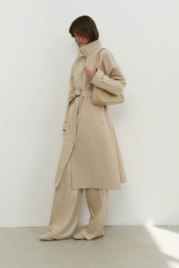 Trenchcoat with a free cut in cream/black