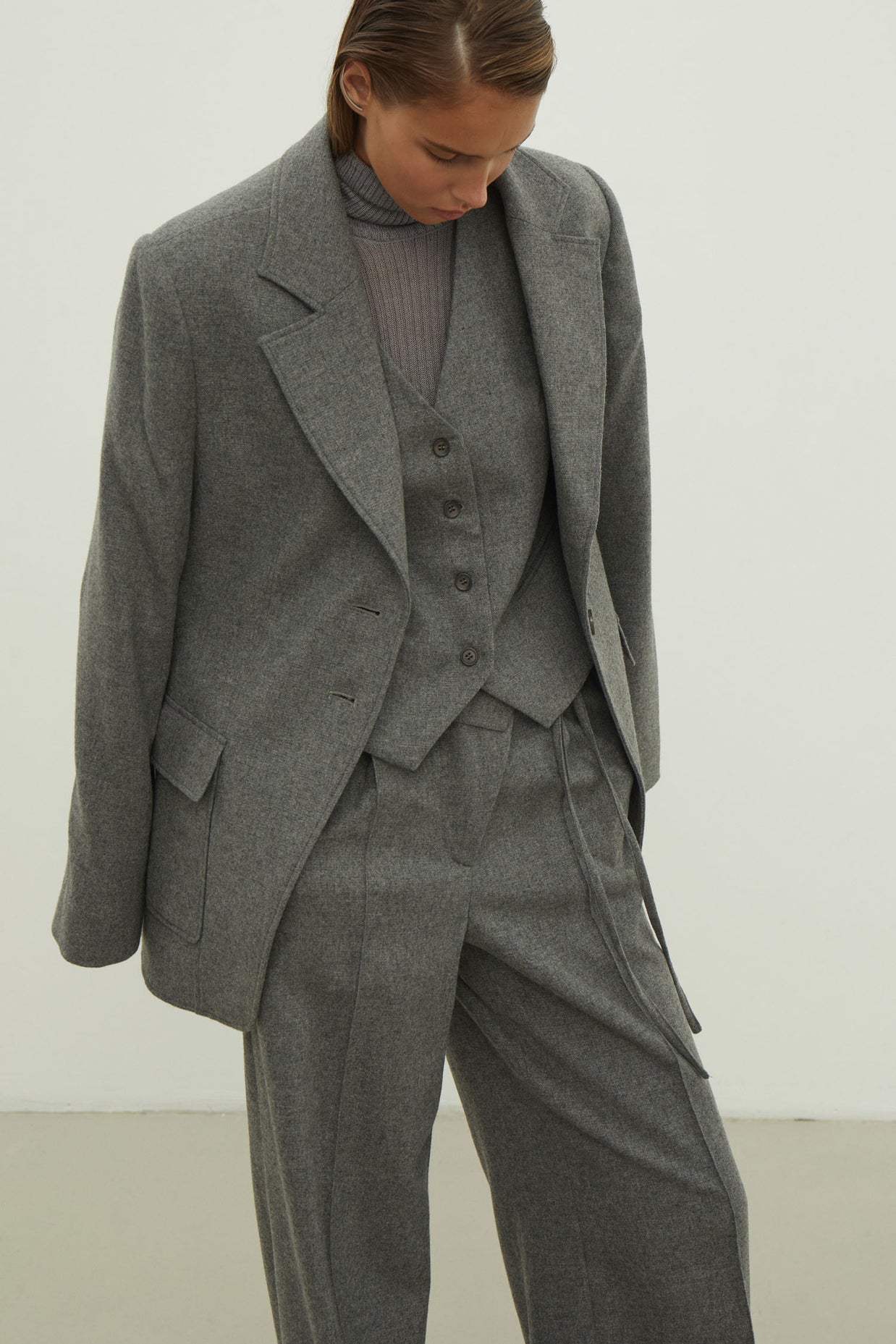 Single-breasted woolen jacket with a tie in gray