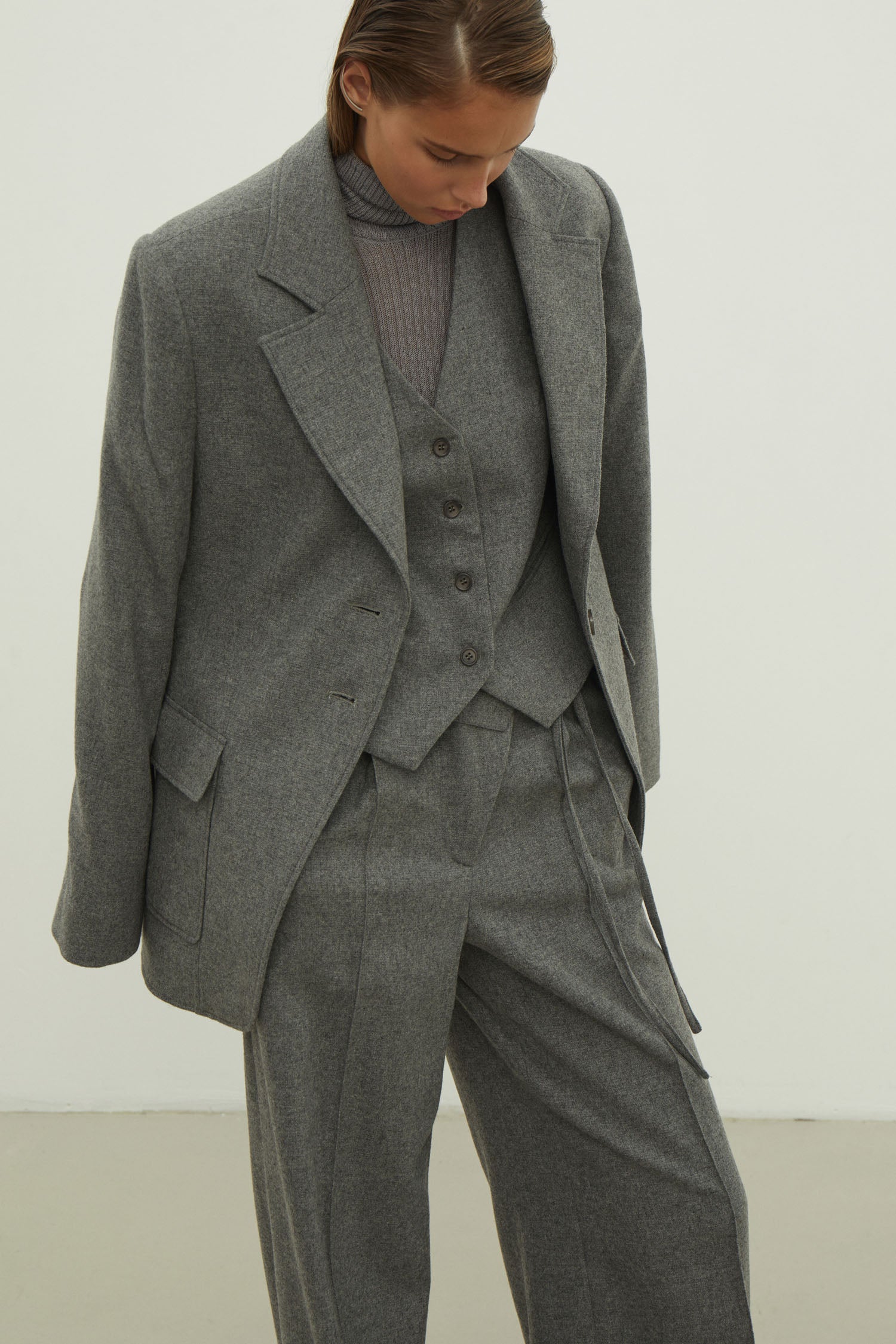 Single-breasted woolen jacket with a tie in gray